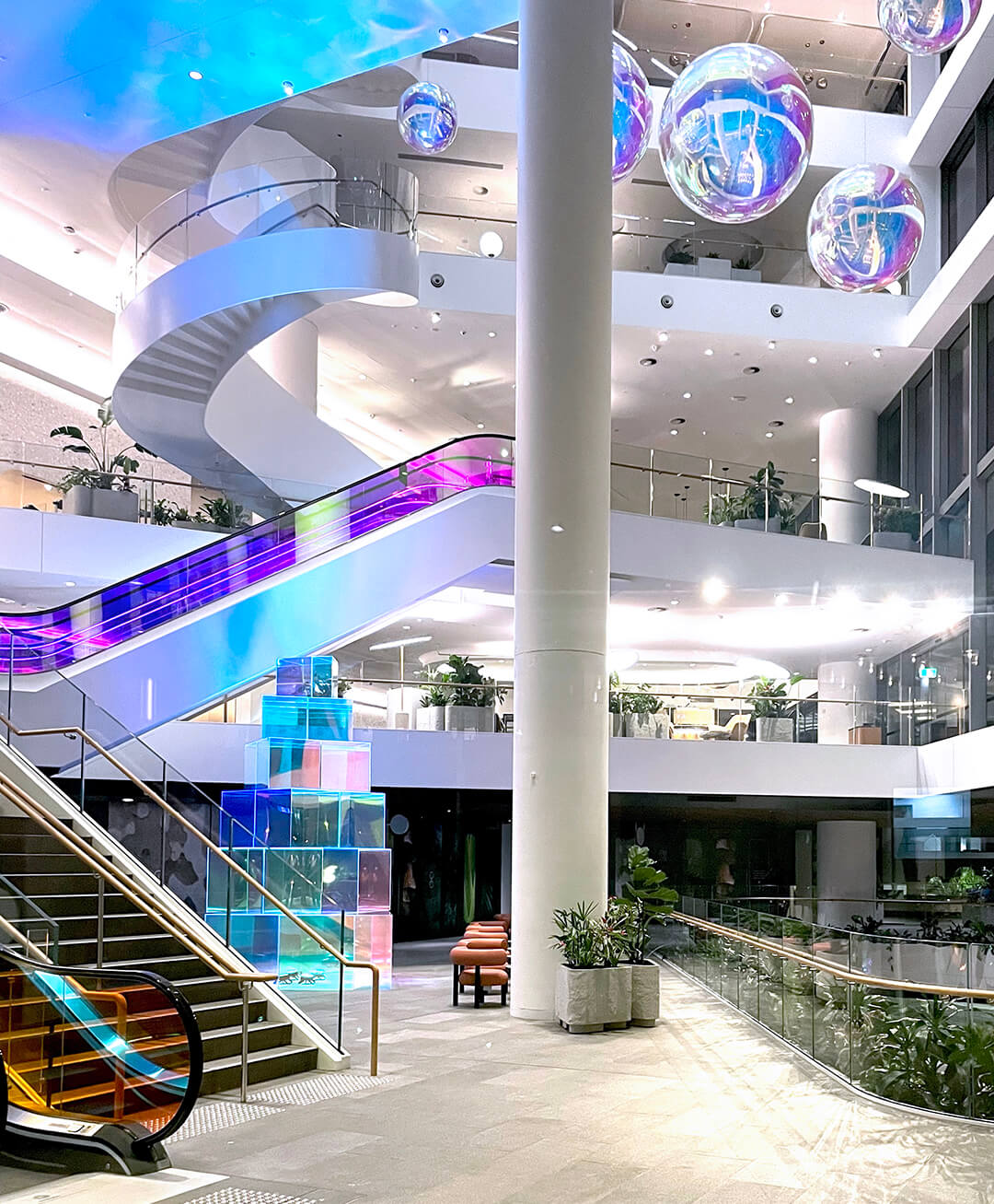 VANDAL Experiential Christmas Campaign for Dexus in the commercial lobby of 50 Bridge Street, Sydney showing dichroic film on escalators and artistic dichroic baubles and Christmas tree.