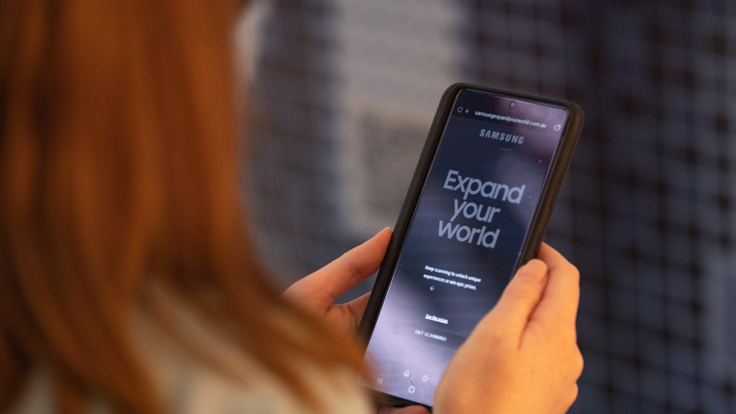 Shoppers interacting with a Sydney based experiential piece for Samsung featuring a still image on a phone allowing participants to interact with brand