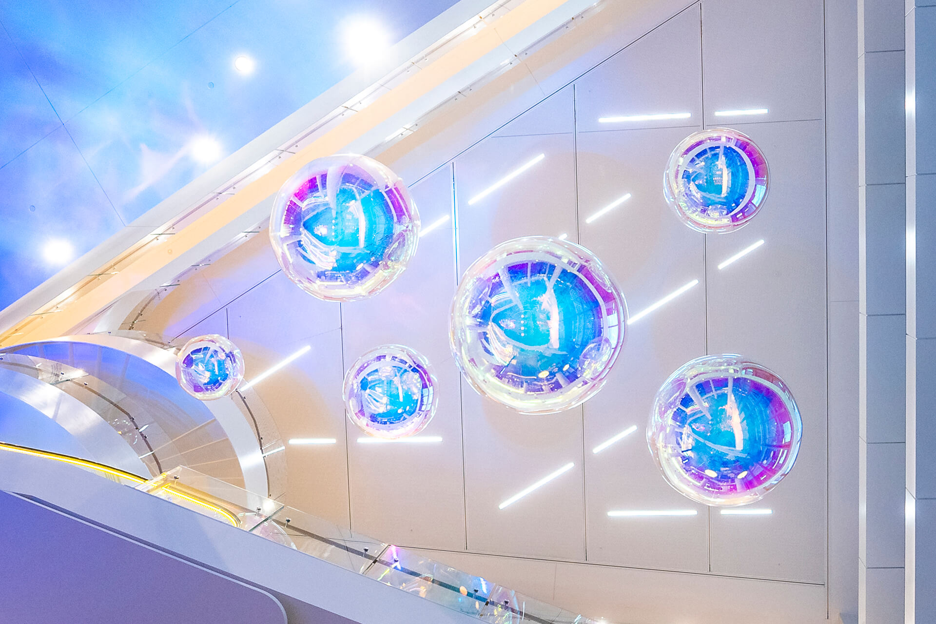 VANDAL Experiential Christmas Campaign for Dexus in the commercial lobby of 50 Bridge Street, Sydney showing dichroic film on escalators and artistic dichroic baubles.