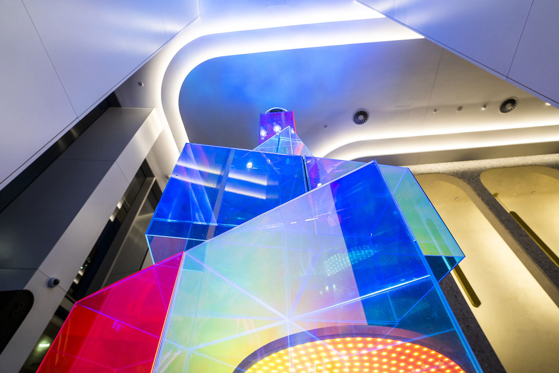 VANDAL Experiential Christmas Campaign for Dexus in the commercial lobby of 50 Bridge Street, Sydney showing dichroic film on escalators and artistic sculpture Christmas tree.