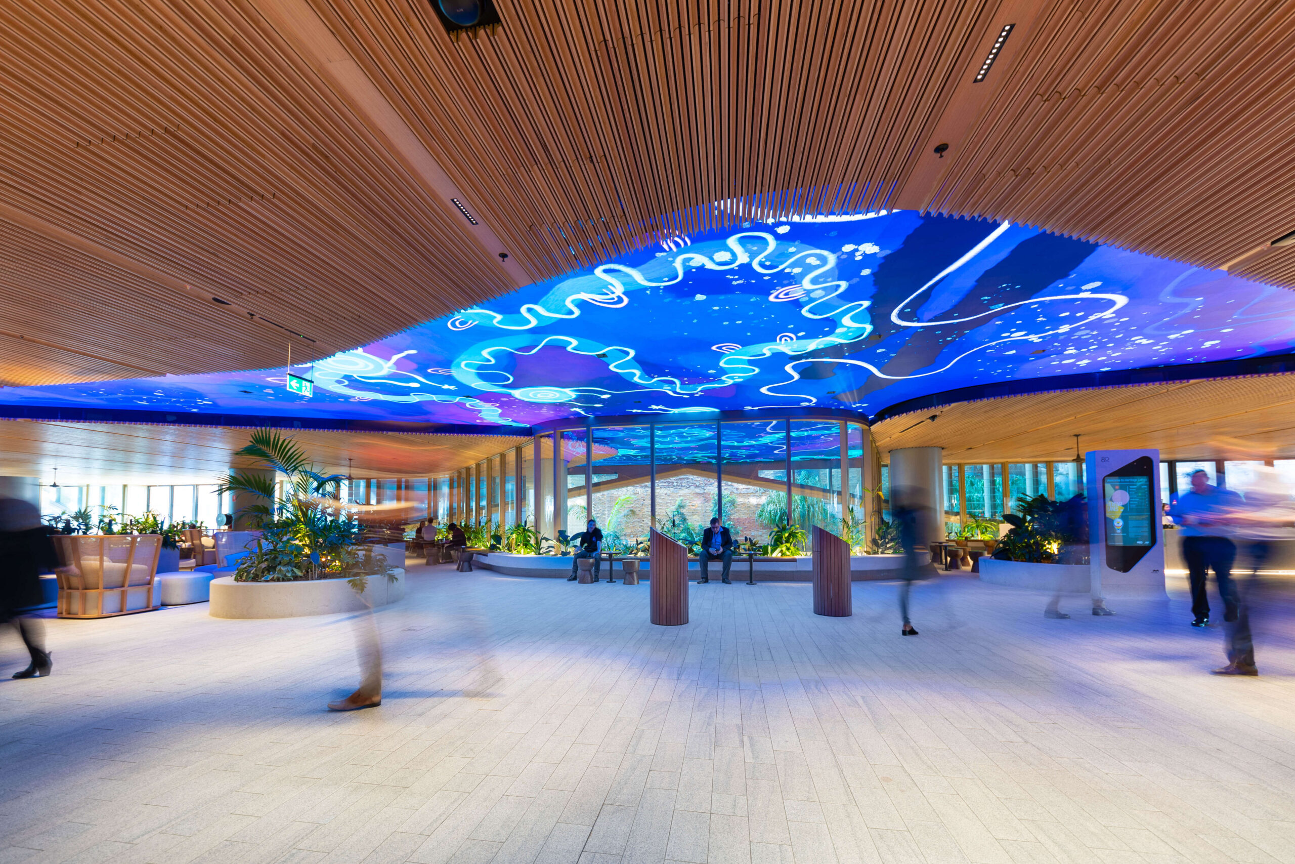 Photo of Mirvac Heritage Lanes commercial lobby foyer in Brisbane Australia showing digital placemaking art screen with vibrant blue indigenous Australian aboriginal artwork created by artist Rachael Sarra in partnership with VANDAL.