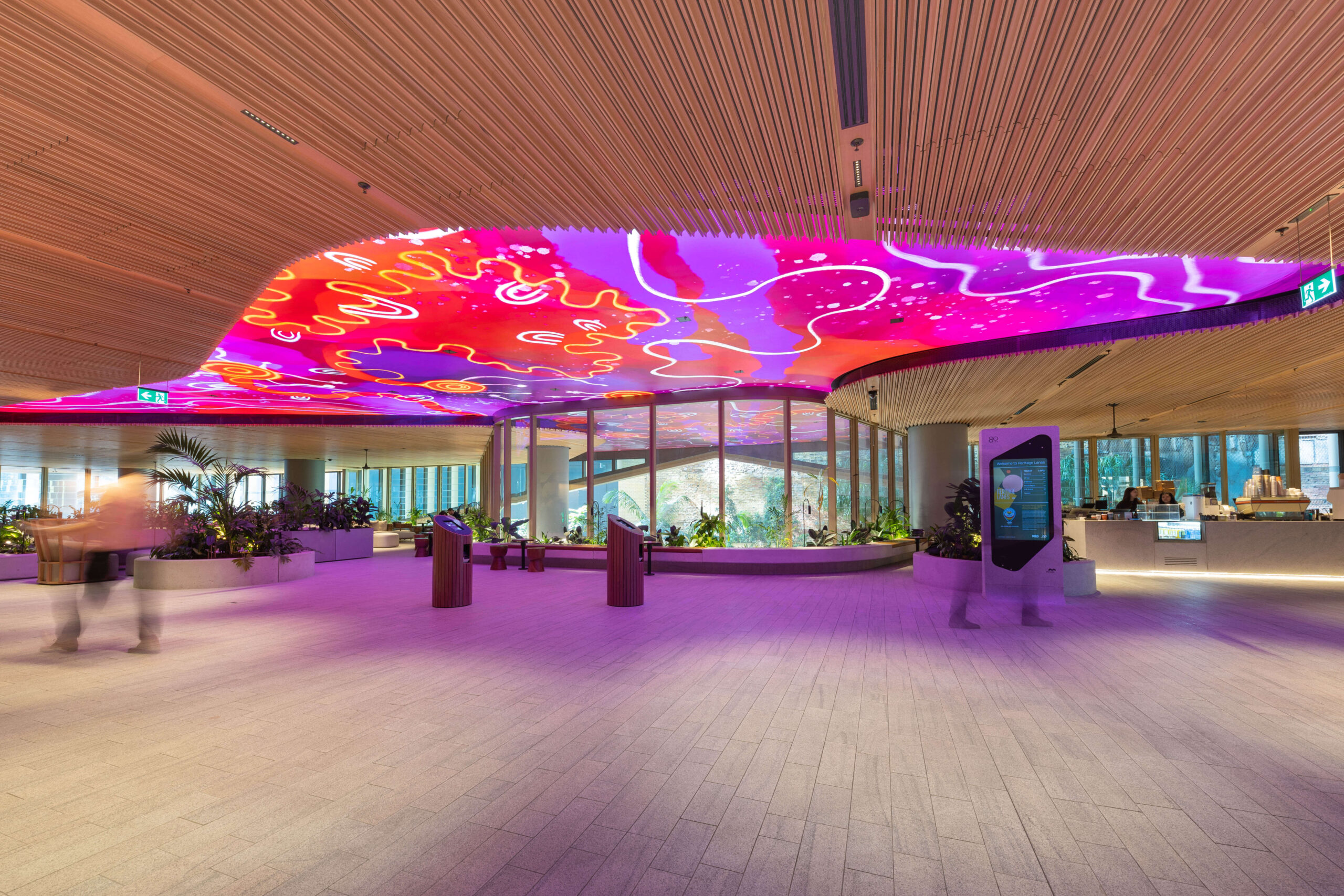 Photo of Mirvac Heritage Lanes commercial lobby foyer in Brisbane Australia showing digital placemaking art screen with vibrant blue indigenous Australian aboriginal artwork created by artist Rachael Sarra in partnership with VANDAL.