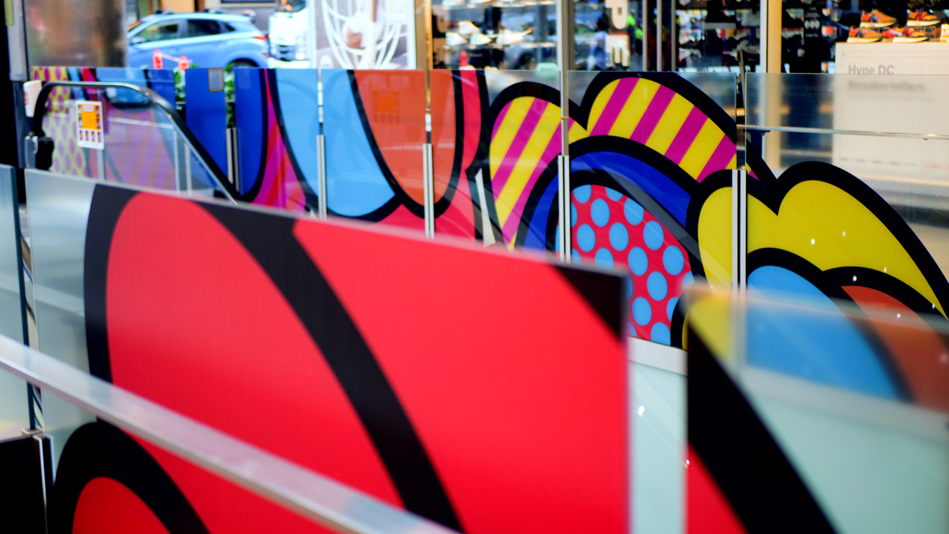 Shoppers enjoying a multicoloured placemaking artistic mural at World Square - a World of Colour by VANDAL