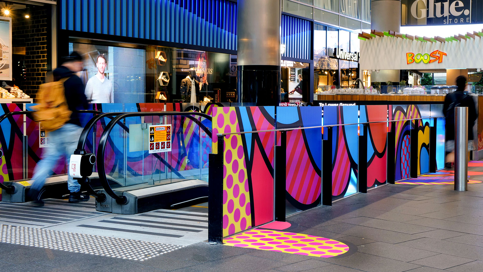 Shoppers enjoying a multicoloured placemaking artistic mural at World Square - a World of Colour by VANDAL